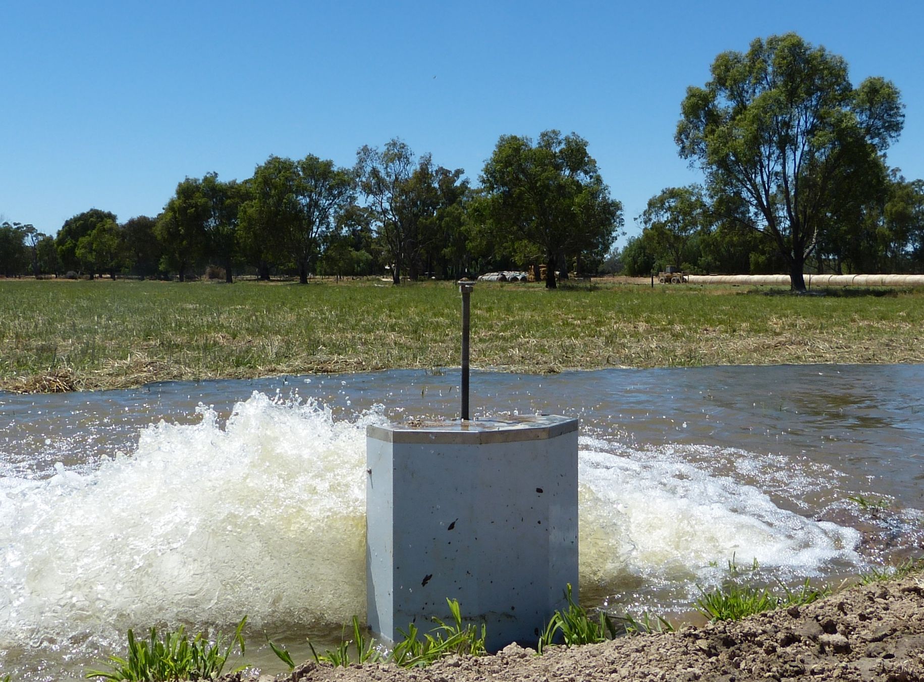 Irrigation water pump spilling water onto a green paddock