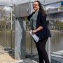 Harriet Shing with dark hair and glasses stands on top of a fishway near Gunbower Creek. 
