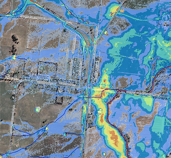 Aerial map of Korong Vale with flood extents in different colours - blue, white, red, and yellow, encompassing most of the town.