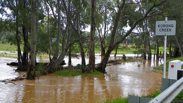 Flooded creek with Korong Creek sign on bridge. Photo is taken from the bridge