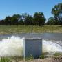 Irrigation water pump spilling water onto a green paddock