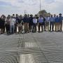 A large group of people standing on the grate of a fishway.